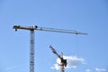 Tower cranes working at construction site on blue sky background Royalty Free Stock Photo