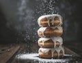 A tower of donuts, glazed and sprinkled with powdered sugar. Wooden table, dark gray background. Sweet dessert