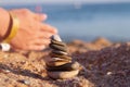 A tower of flat stones with a white shell on the beach by the sea. Hello sea. Stone pyramid on the sand. Summer warm Royalty Free Stock Photo