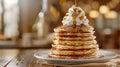 A tower of fluffy pancakes stacked high and drizzled with warm maple syrup and topped with a dollop of whipped cream