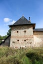 The tower of the fortress wall in the grass, Pskov-Pechory Dormition Monastery in Pechory, Pskov region, Russia under blue sky Royalty Free Stock Photo