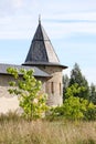 The tower of the fortress wall in the grass, Pskov-Pechory Dormition Monastery in Pechory, Pskov region, Russia under blue sky Royalty Free Stock Photo