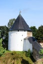 The tower of the fortress wall in the grass, Pskov-Pechory Dormition Monastery in Pechory, Pskov region, Russia under blue sky Royalty Free Stock Photo