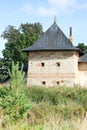 The tower of the fortress wall in the grass, Pskov-Pechory Dormition Monastery in Pechory, Pskov region, Russia under blue sky Royalty Free Stock Photo