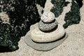 Tower of river rocks, four, zen on beach with sand and jetty rocks Royalty Free Stock Photo