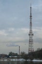 A tower for 4g and 5g mobile communication systems against a cloudy sky background. Cellular base station on the shore of the lake Royalty Free Stock Photo