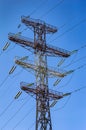 Tower with high-voltage energy transmission wires against the blue sky. Royalty Free Stock Photo