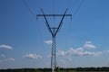 Tower with high-voltage energy transmission wires against the blue sky. Royalty Free Stock Photo