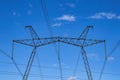 Tower with high-voltage energy transmission wires against the blue sky. Royalty Free Stock Photo