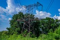 Tower with high-voltage energy transmission wires against the blue sky. Royalty Free Stock Photo