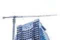 Tower industrial crane builds new concrete city modern building in winter in snow and cold on construction site Royalty Free Stock Photo