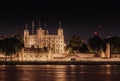 Tower of london illuminated at night in front of thames river
