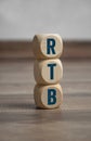 Tower made of cubes and dice with acronym RTB - Real Time Bidding - on wooden background