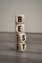 Tower made of Cubes and dice with best and better on wooden background