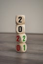 Tower made of cubes and dice with 2020 and 2021 on wooden background