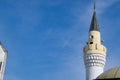 tower of the minaret of the mosque against the blue sky and the contrail from aircraft Royalty Free Stock Photo