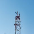 tower for mobile communication antennas against a blue sky with white clouds. Mobile operator antennas. Radio Royalty Free Stock Photo