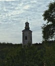 Tower of monastery church, forest and sky around