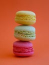 tower of multi-colored assorted bright macaroons close-up, on orange background