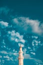 A mosque tower with negative space of a blue skies and clouds