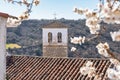 Tower of the old church made of stone that appears among the almond blossoms, Olmeda de las Fuentes, Madrid. Royalty Free Stock Photo