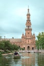 Tower of the Plaza de EspaÃÂ±a, Seville, next to boat navigating its canals Royalty Free Stock Photo