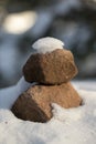 Tower of stacked sandstones on the forest floor with snow