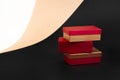a tower of three golden-red boxes on a background of beige, black, and white paper Royalty Free Stock Photo