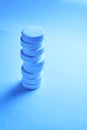 Tower of vitamin tablets on blue background