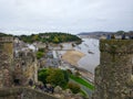 Tower and walls of Conwy Castle, an ancient 13th Century stone built fortification in North Wales, with a landscape and River
