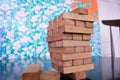 Tower of wooden blocks balanced on a single block on a office table. Business concept.
