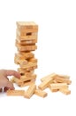 Tower from wooden blocks and man`s hand take one block Royalty Free Stock Photo