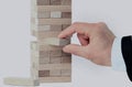 The tower from wooden blocks and man`s hand take one block Royalty Free Stock Photo