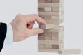 The tower from wooden blocks and man`s hand take one block Royalty Free Stock Photo