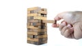 The tower from wooden blocks and man`s hand take one block. The game of dice close-up Royalty Free Stock Photo