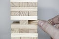 The tower from wooden blocks and man`s hand take one block Royalty Free Stock Photo