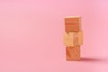 Tower of wooden cubes on a pink background. Childrens toys from natural materials concept zero West. Horizontal frame