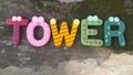 Tower word from colourful wooden stick on mossy table background