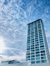 Huge blue business building with blue glass window. blue sky and white clouds background. Royalty Free Stock Photo