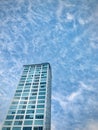 Towering blue glass buildings pointing to the blue sky and white clouds. Royalty Free Stock Photo