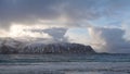 Towering clouds from Ramsberg beach on Flakstad island on the Lofoten islands in winter at sunset