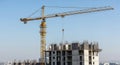 Towering construction crane overseeing a building under development against a clear sky Royalty Free Stock Photo