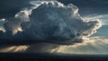 Towering cumulonimbus clouds dominate the sky, with sunrays piercing through gaps, creating dramatic shafts of light. Royalty Free Stock Photo
