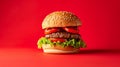 The Towering Delight: An Epic Hamburger Amidst a Vibrant Red Backdrop
