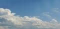 Towering fluffy clouds building in big blue sky - horizontal background Royalty Free Stock Photo