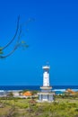 Towering lighthouse tower stands sentinel over the crashing waves at Padawa Beach, Bali, Indonesia.