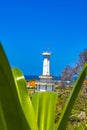 Towering lighthouse tower stands sentinel over the crashing waves at Padawa Beach, Bali, Indonesia.