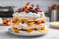 towering meringue dessert with layers of fruit and cream