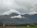 Towering mountains with white clouds and rice fields Royalty Free Stock Photo