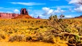 The towering red sandstone formation of West Mitten Butte and a fallen tree in the Navajo Nation`s Monument Valley Royalty Free Stock Photo